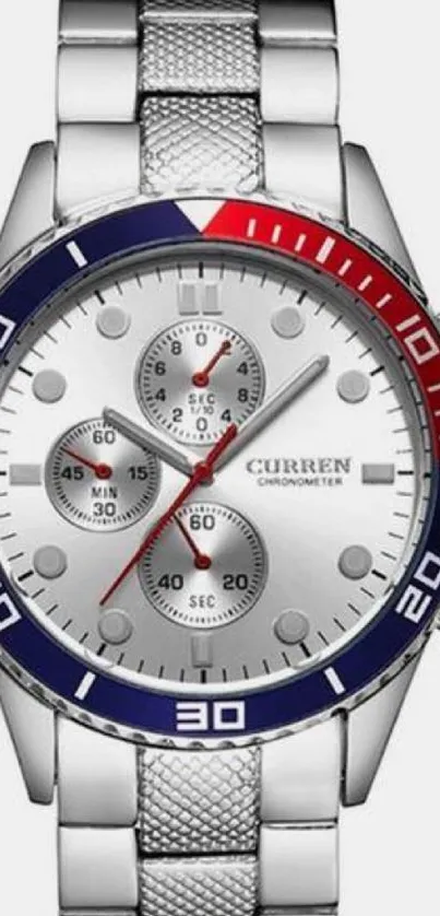 Silver watch with red and blue bezel, stylish design.