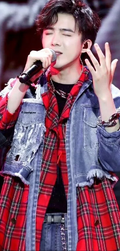 Singer performing passionately in plaid jacket wallpaper.