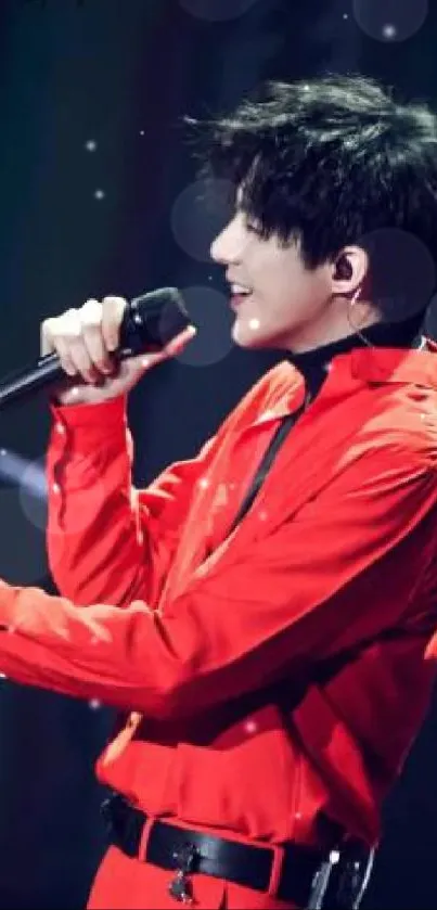 Singer performing passionately in red outfit on stage.