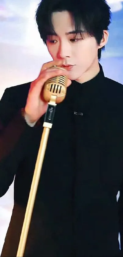 Singer in black outfit with gold microphone on stage.