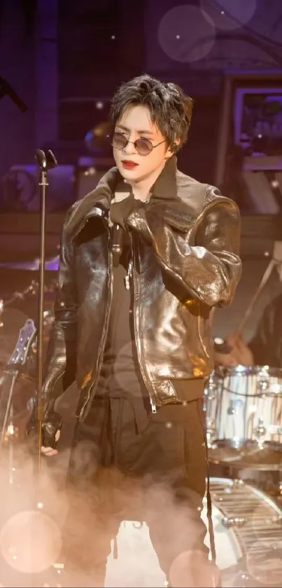 Singer in leather jacket performing on stage.