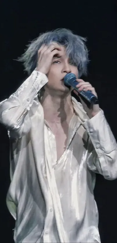 Singer performing with a microphone and stylish outfit on stage.