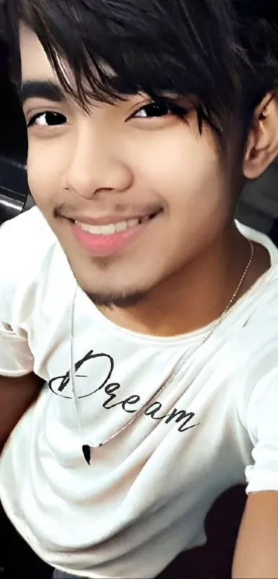 Young man smiling in a white shirt with 'Dream'. Modern and stylish portrait.