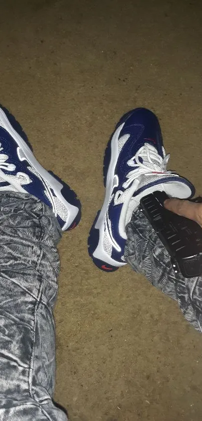 Blue sneakers and patterned pants on tan background.