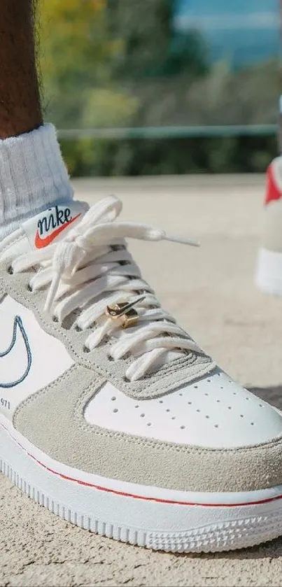 Close-up of white and beige sneakers on a sunny pavement.