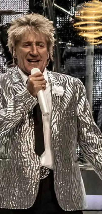 Vibrant stage performance with a silver jacket-clad performer holding a microphone.