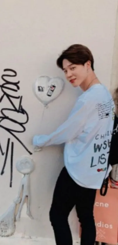 Stylish young man poses in front of urban street art.