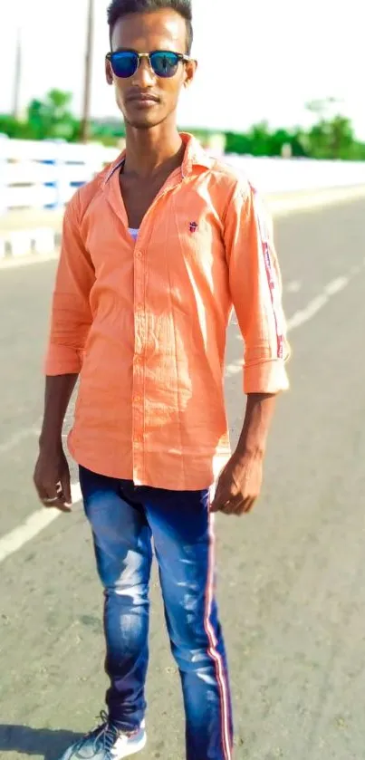 Stylish young man on a sunny urban road wearing reflective sunglasses.