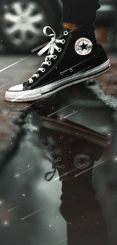 Black sneaker with reflection in water puddle on street.