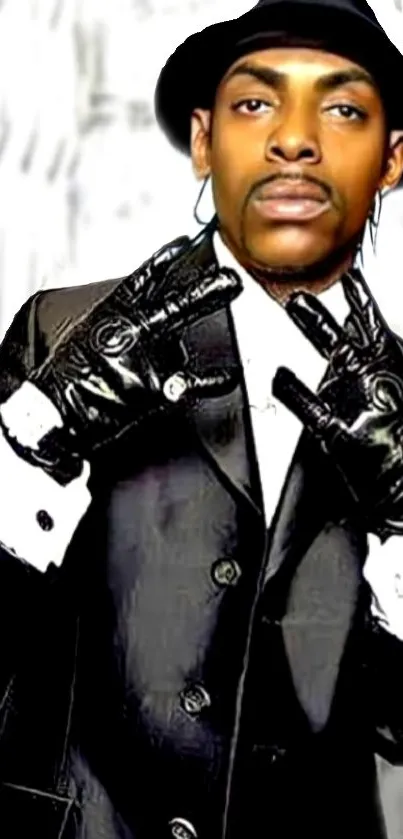 Man in black suit and gloves, striking a stylish pose.