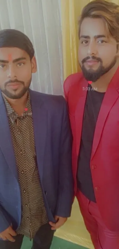 Two stylish men in vibrant suits posing for a mobile wallpaper.