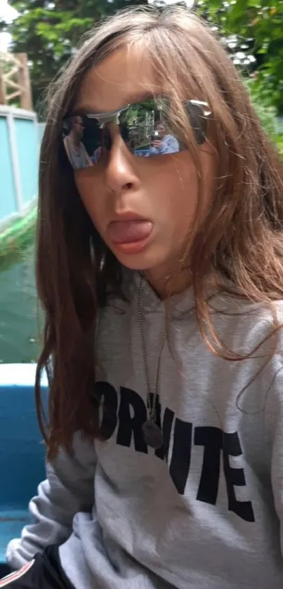 Person wearing sunglasses on a boat surrounded by nature.