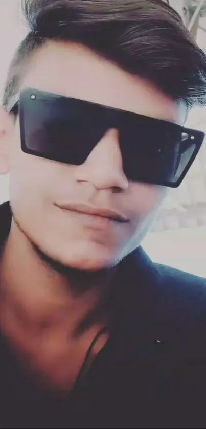 Person wearing oversized sunglasses in a stylish wallpaper.