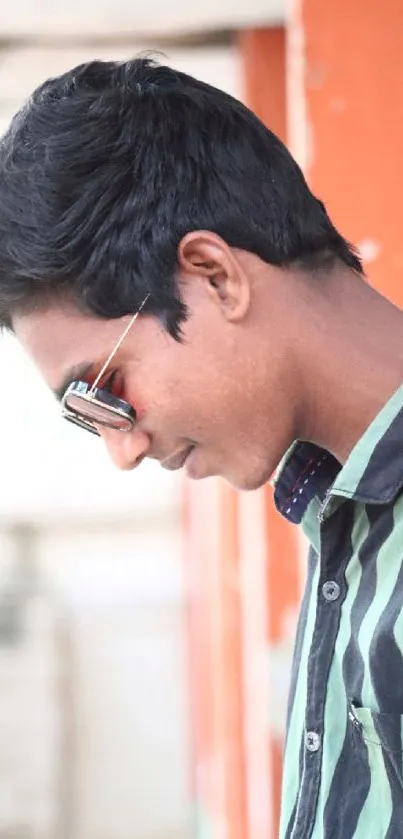 Young man in sunglasses with striped shirt, modern look.