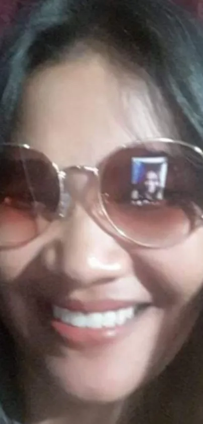 Person smiling with sunglasses in a selfie.