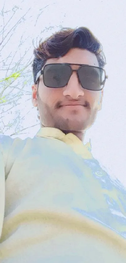 Selfie of a young man with sunglasses on a sunny day under a clear sky.