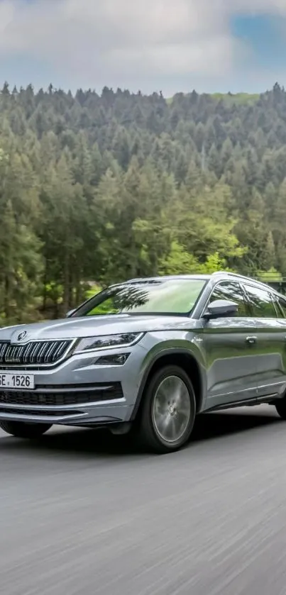 Sleek SUV driving through a lush forest setting on a clear day.