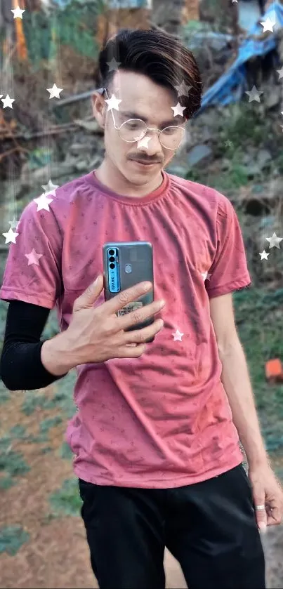 Man in a pink shirt using a smartphone outdoors.