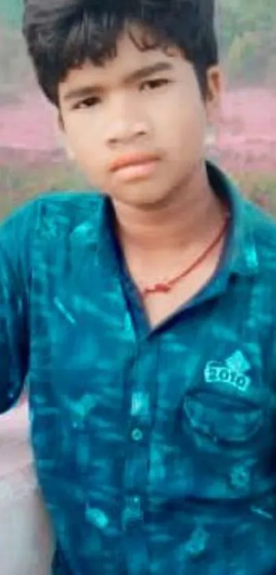 Teen wearing a blue shirt with a natural backdrop.