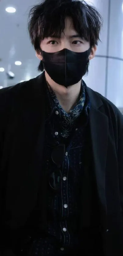 Person in a trendy black outfit with mask in an urban setting.