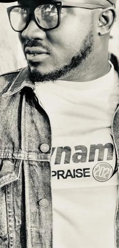 Monochrome portrait of a man wearing a denim jacket and glasses.