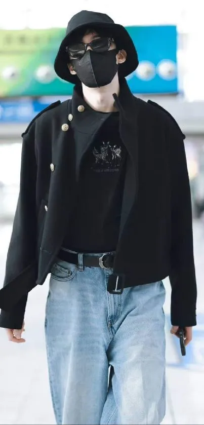 Person in stylish urban outfit, black hat and mask, walking indoors.
