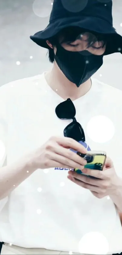 Person wearing bucket hat and mask, using phone.