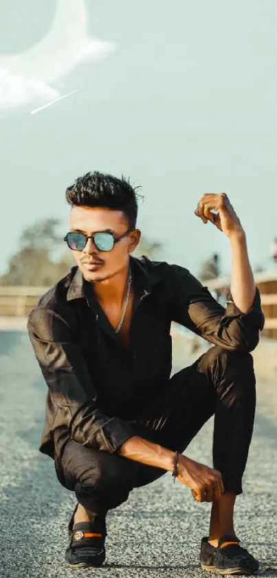 Stylish man posing on a bridge under a crescent moon.