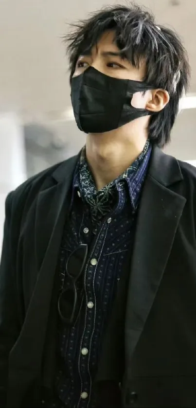 Stylish person in urban attire with mask in sleek fashion.