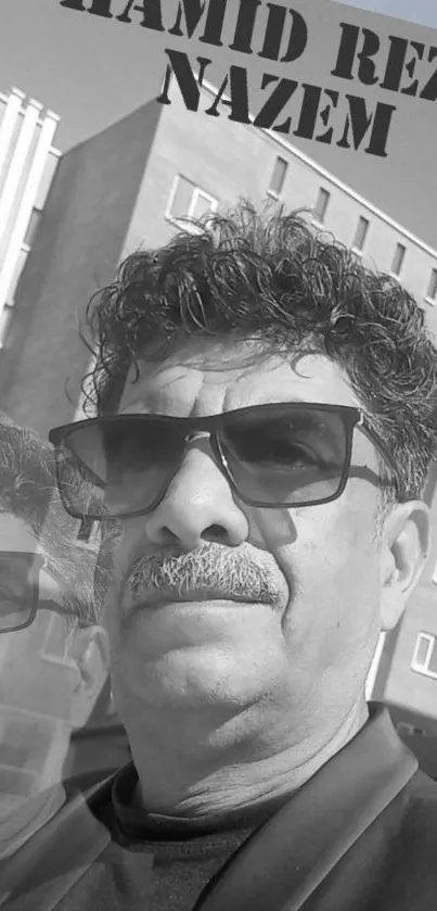 Black and white urban portrait with sunglasses in city setting.