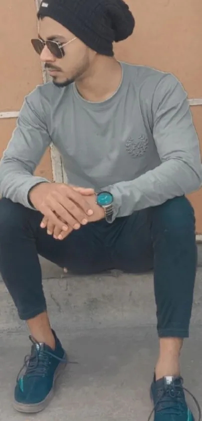 A young man in stylish streetwear, sitting casually.