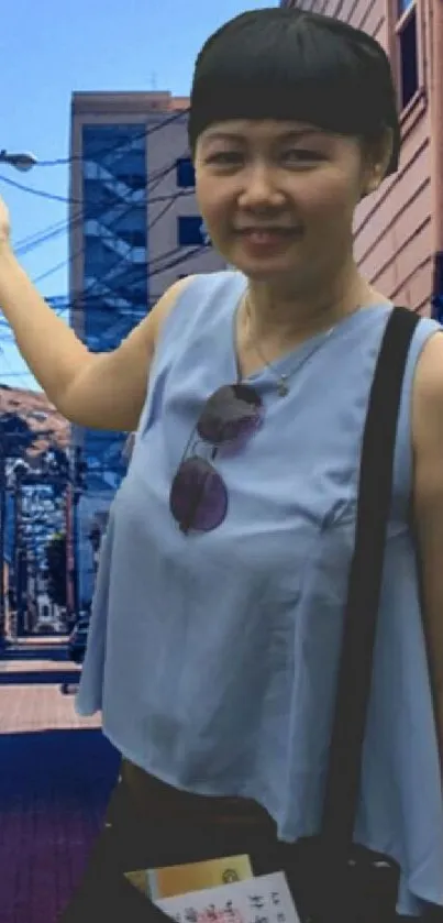 Woman in urban street with light blue top.