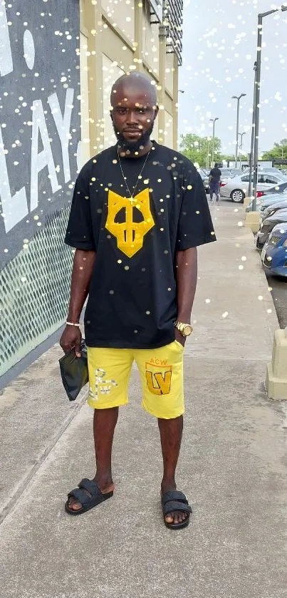 A man in yellow urban streetwear poses on a city sidewalk.