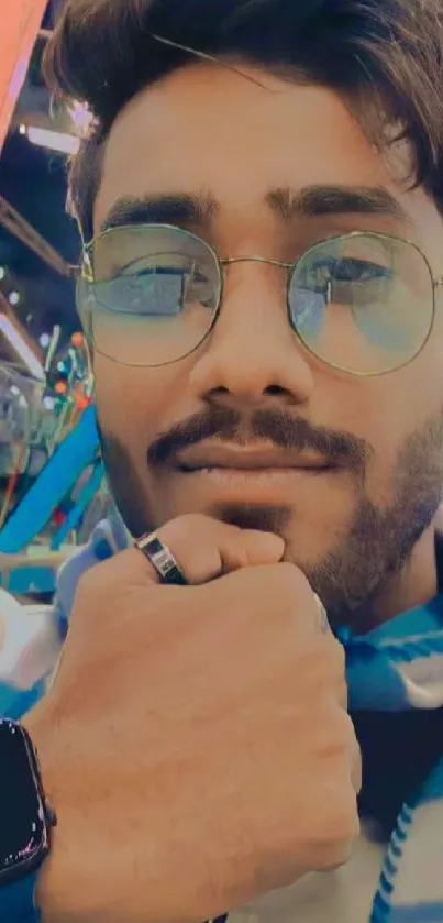 Stylish man wearing glasses with vibrant city background.