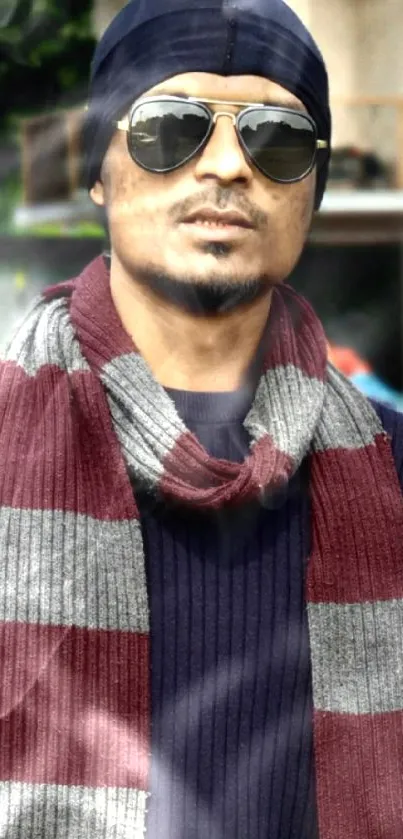 Fashionable person in winter attire with scarf and sunglasses.