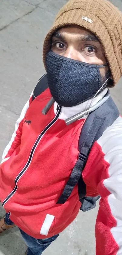 Man in red jacket, beanie, and mask street portrait.