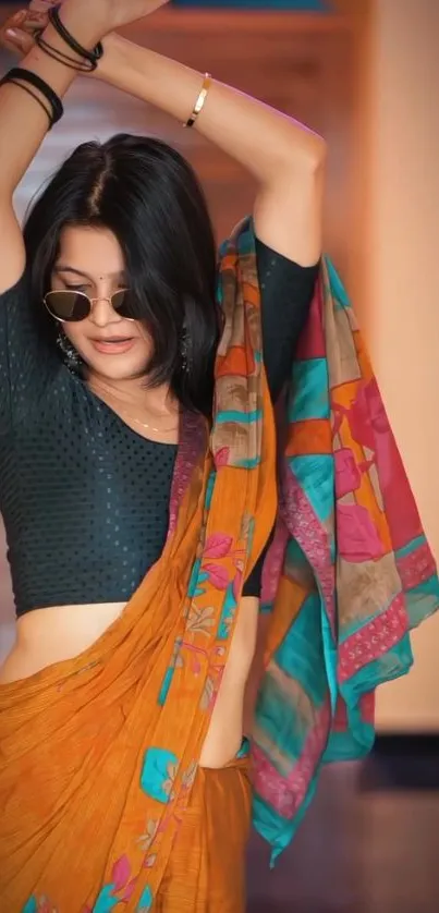 A stylish woman in a colorful saree posing elegantly.