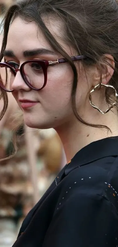 Woman with glasses and gold hoop earrings in a stylish portrait.