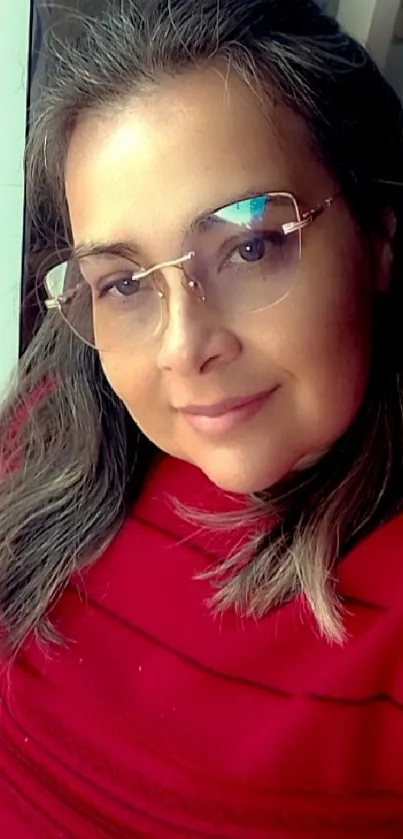 Woman in red outfit with glasses, smiling.