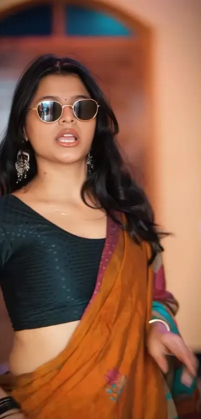 Woman wearing an orange saree and sunglasses