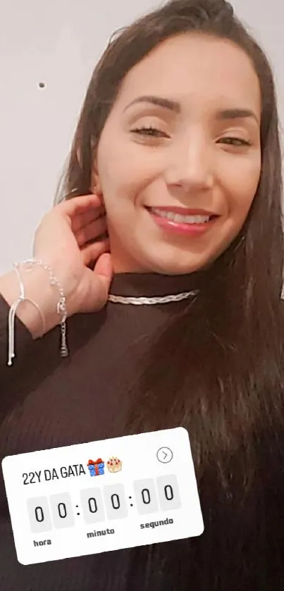 Woman taking a selfie with a joyful smile, wearing a black top and jewelry.