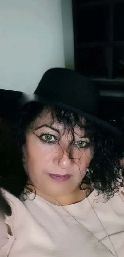 Woman with black hat and curly hair in a fashionable outfit