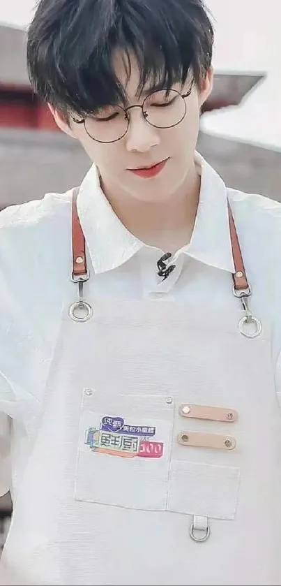 Young man in a white apron looking down peacefully.