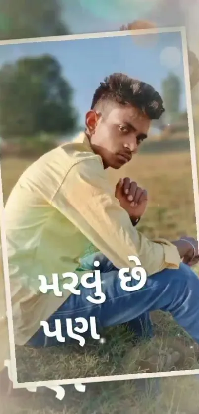 Young man in yellow shirt sitting outdoors with a nature background.