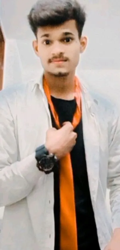 Young man in a stylish outfit with orange tie in modern setting.