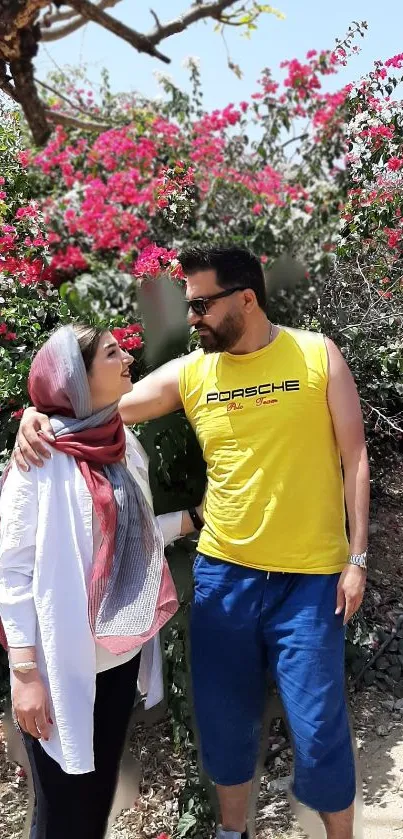 Couple in summer attire with pink blossoms.