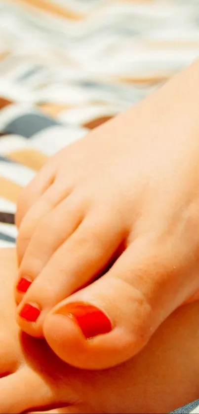 Cozy feet with red nails resting on beach-patterned fabric.