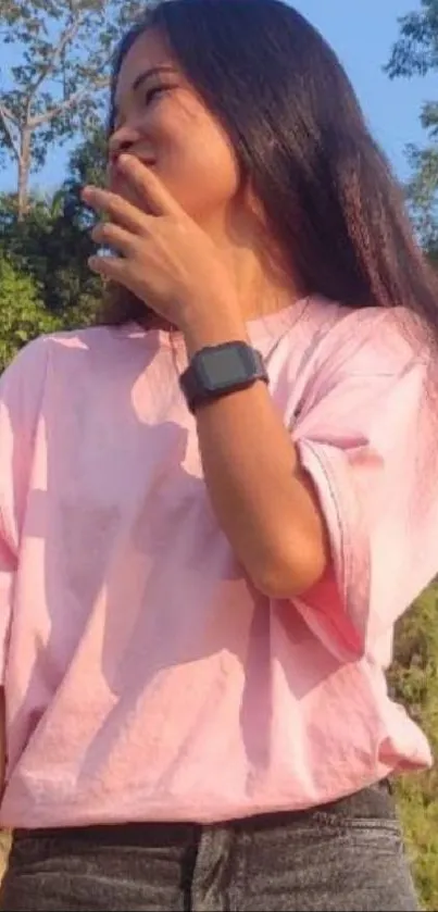 Woman in pink shirt with natural sunlight background.