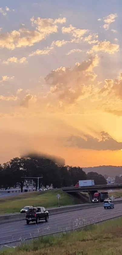 Golden sunset over a highway with cars and dramatic clouds.