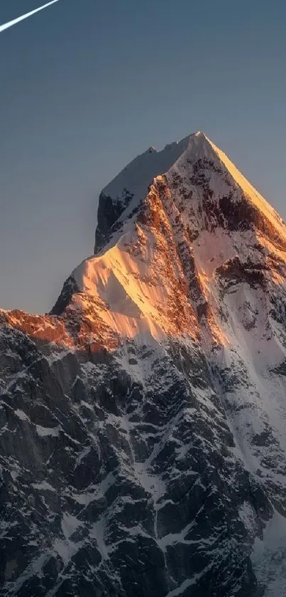 Sunlit mountain peak against blue sky wallpaper.